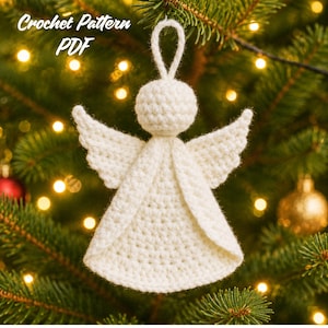 Peut inclure: Un ornement d'ange crocheté en blanc avec une tête ronde, un corps évasé et des ailes texturées. Une boucle sur le dessus permet de le suspendre. Le texte "Crochet Pattern PDF" est visible dans le coin supérieur gauche de l'image.
