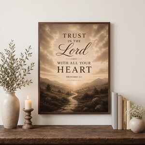 Op de afbeelding: Een ingelijste wandkunstprint met een sepia-getint landschap van een kronkelend stenen pad dat leidt naar een zonsopgang boven verre bergen. De tekst luidt: TRUST IN THE Lord WITH ALL YOUR HEART PROVERBS 3:5 in een mix van schreef- en scriptlettertypes.