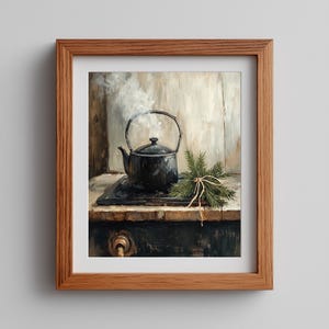 May include: A framed print of a still life featuring a black teapot on a stove, with steam rising from the spout. A bundle of evergreen sprigs tied with twine sits nearby. The artwork has a rustic, vintage aesthetic.