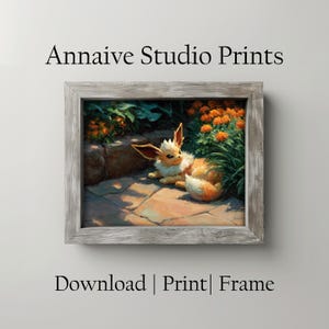 May include: A rectangular wooden frame containing a digital art print of a tan and cream-coloured fox-like creature resting on a stone path near orange flowers. The text "Annaive Studio Prints" appears above the frame, and "Download | Print | Frame" below.