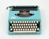 1966 Brother Deluxe 100 Manual Typewriter - Small Turquoise / Aqua Blue. Comes with case and original manual. Is in near perfect condition.