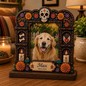 May include: A dark wooden picture frame featuring a central photo of a golden retriever. The frame is decorated with colorful flowers, a skull at the top, bone icons, and candles. A plaque at the bottom displays the text Max 2013-2024.