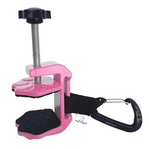May include: A pink clamp with a black screw and handle. The clamp has a black strap and a black carabiner clip. The clamp has a black rubber pad on the bottom and a black rubber pad on the top.