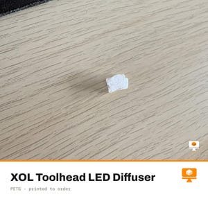 May include: A small, translucent white XOL Toolhead LED diffuser component. The object features a textured, semi-clear surface designed for light dispersion, with a compact, irregular geometric shape intended for 3D printer toolhead assembly.