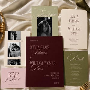 May include: A wedding stationery suite featuring a deep burgundy invitation, a sage green thank you card with a black and white photo, a cream-colored invitation, a sage green details card, a cream save the date with photos, and a light pink RSVP card.