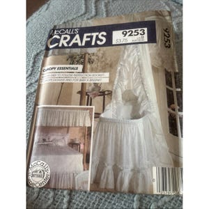 May include: A McCall's Crafts sewing pattern envelope, number 9253, featuring Canopy Essentials. The cover displays illustrations of a white ruffled bassinet canopy and a bed canopy, with text including '5 canopy designs and for baby a bassinet'.