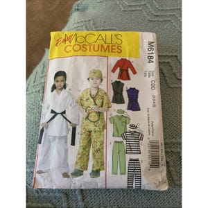 May include: A McCall's Costumes sewing pattern envelope M6184 for sizes CDD (2-3-4-5). The front features illustrations of children wearing a white martial arts uniform and a green patterned doctor outfit with a stethoscope, plus line drawings of costumes.