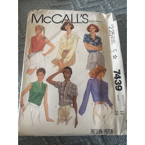 May include: A McCall's sewing pattern envelope, number 7439, for miss size 16 with a 38 inch bust. The front displays illustrations of six different shirt and blouse styles, including sleeveless, short-sleeved, and long-sleeved options in various colors.