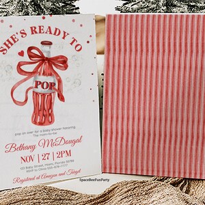 May include: A baby shower invitation with a red and white design. The front displays a watercolour illustration of a soda bottle with a bow and the word "POP". The invitation includes the text "She's Ready To" and event details.