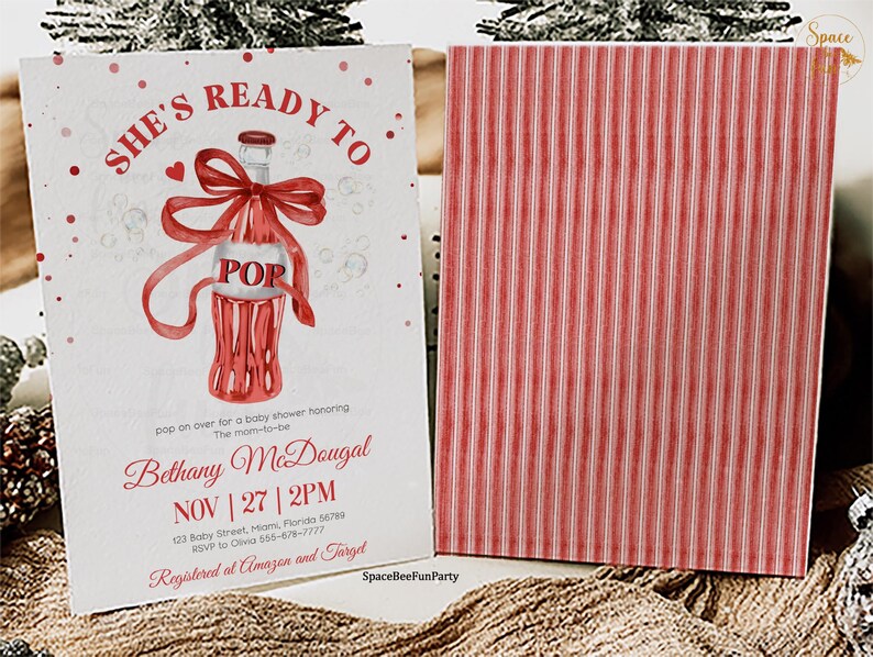 May include: A baby shower invitation with a red and white design. The front displays a watercolour illustration of a soda bottle with a bow and the word "POP". The invitation includes the text "She's Ready To" and event details.