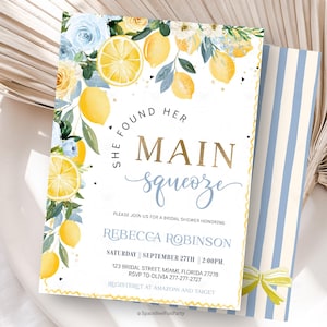 Puede incluir: Invitación a una despedida de soltera con tema de limón. La invitación presenta el texto "She Found Her Main Squeeze" en oro y escritura azul claro. El diseño incluye limones, rosas azules y un sobre a rayas.