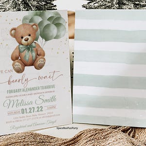 May include: Baby shower invitation featuring a watercolor teddy bear holding balloons. The invitation reads "We can bearly wait for baby Alehander to arrive." The back of the invitation has horizontal stripes in shades of green and white.