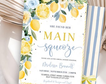Könnte beinhalten: Einladungskarte zur Brautparty mit Zitronen-Thema. Die Einladung zeigt gelbe Zitronen und blaue Blumenakzente. Der Text lautet "She Found Her Main Squeeze" und enthält Eventdetails.
