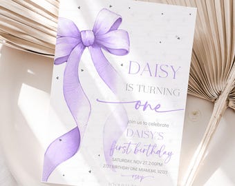 May include: A light purple birthday invitation with a watercolor bow and flowing ribbons. The text reads "DAISY IS TURNING one" and details for the first birthday celebration. The invitation is on a white background.