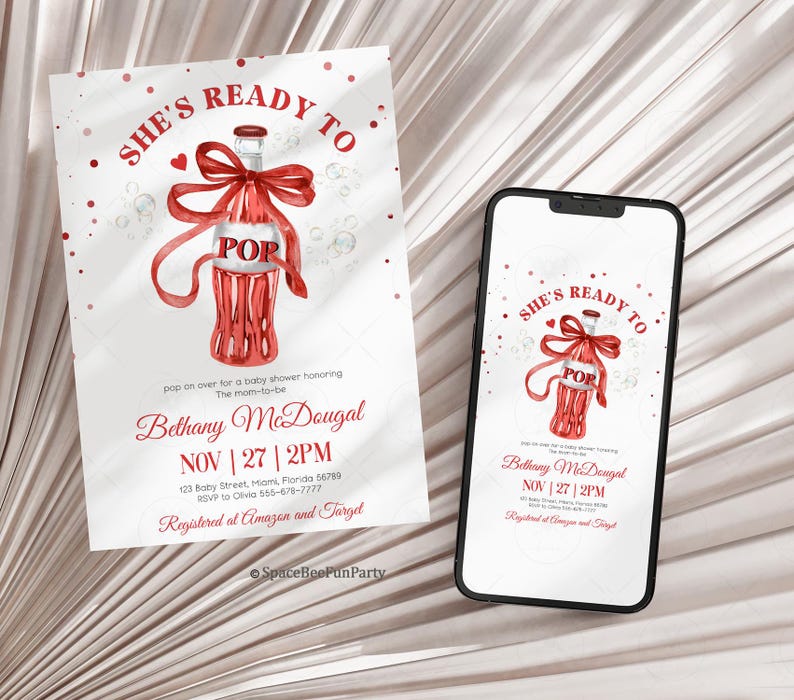 May include: A baby shower invitation and a smartphone showing the same design. The invitation features a red bottle with a bow, the word "POP", and the text "SHE'S READY TO". The invitation also includes event details.