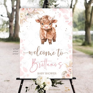 Pode incluir: Um letreiro de boas-vindas para chá de bebé com uma ilustração de uma vaca Highland castanha e detalhes florais. O letreiro diz "welcome to Brittani's BABY SHOWER". Disponível em 40.6cm x 50.8cm, 45.7cm x 61cm e 61cm x 91.4cm.