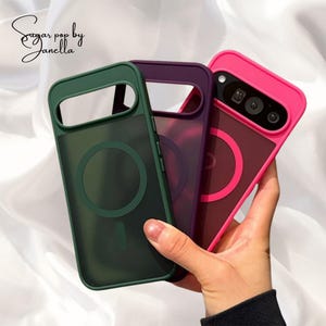 Puede incluir: Tres fundas de teléfono coloridas en verde, morado y rosa. Cada funda tiene un recorte para la cámara y un diseño circular. Las fundas se sostienen sobre un fondo blanco. El texto "Sugar pop by Janella" está en la esquina superior izquierda.