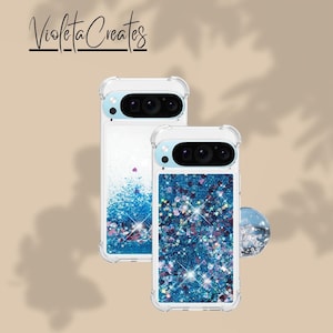 May include: Two clear phone cases with a glittery blue and purple design. One case has a blue glitter design with stars and the other has a blue glitter design with a few purple accents. The text "Violeta Creates" is at the top.