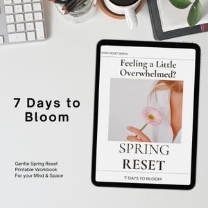 May include: A digital tablet displays the text "Feeling a Little Overwhelmed?" and "Spring Reset." The tablet is on a white surface with a keyboard and coffee cup. The text "7 Days to Bloom" is also visible, along with "Gentle Spring Reset Printable Workbook For your Mind & Space."