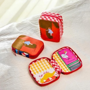 May include: A set of red and white gingham patterned cosmetic bags with illustrations. One bag features a girl in a blue dress, another has the text "Egg dishes", and the third contains a stack of cards with a ballerina. The bags have red zippers.