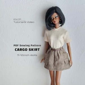 May include: A doll with dark hair wearing a cream-colored short-sleeve top and a brown textured cargo skirt with side pockets and a thin belt. Text reads: EN/JP Tutorial & Video, PDF Sewing Pattern, CARGO SKIRT, 11-12inch dolls.