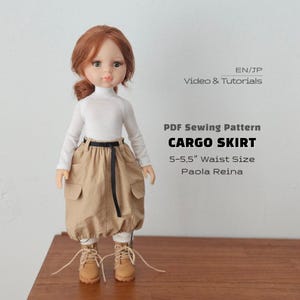 May include: A doll with auburn hair wearing a white long-sleeve shirt, a tan cargo skirt with a black belt, and tan lace-up boots. Text reads: EN/JP Video & Tutorials, PDF Sewing Pattern CARGO SKIRT, 5-5.5" Waist Size, Paola Reina.