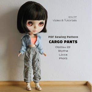 May include: A doll with short black hair and orange eyes wearing a light blue cropped jacket, an orange crop top, and gray cargo pants with white sneakers. Text reads: EN/JP Video & Tutorials, PDF Sewing Pattern, CARGO PANTS, Obitsu 22, Blythe, Licca, PNXS.