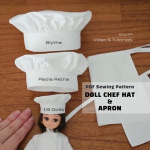 May include: Three white fabric chef hats of varying sizes labeled Blythe, Paola Reina, and 1/6 Dolls, alongside a white fabric apron. Text on the image reads EN/JP Video & Tutorials and PDF Sewing Pattern DOLL CHEF HAT & APRON.