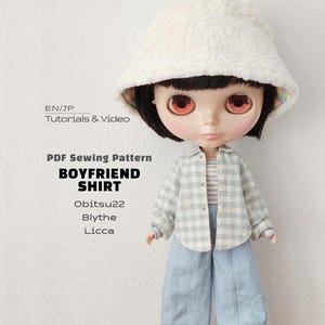 May include: A doll with black hair and orange eyes wearing a white fuzzy bucket hat, a light blue and white checkered button-down shirt, a striped top, and light blue pants. Text reads: EN/JP Tutorials & Video PDF Sewing Pattern BOYFRIEND SHIRT Obitsu22 Blythe Licca.