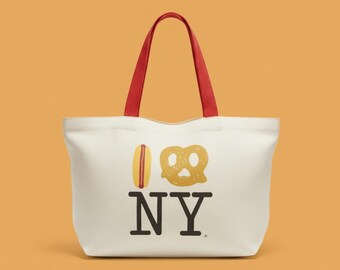 May include: Off-white tote bag with red handles. The bag features a graphic of a hot dog and pretzel with the letters "NY" in black, representing New York City.