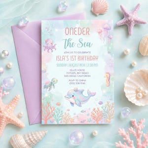 May include: A pastel-colored birthday invitation with the text "ONEDER The Sea" and "ISLA'S 1ST BIRTHDAY". The invitation features illustrations of sea creatures like a dolphin, octopus, and seahorse. The invitation is surrounded by seashells and pearls.