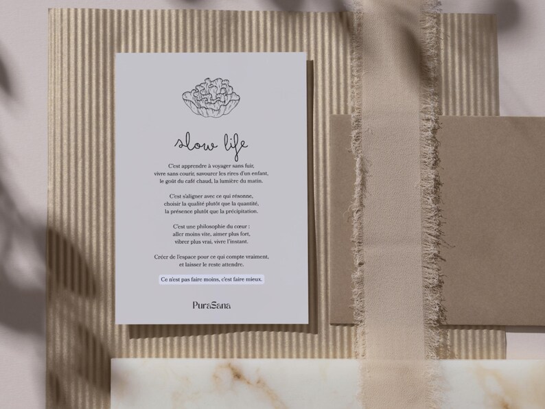 May include: A light gray card with the words "slow life" and a floral illustration. The card has French text and is set against a textured background with neutral tones, including beige and brown.