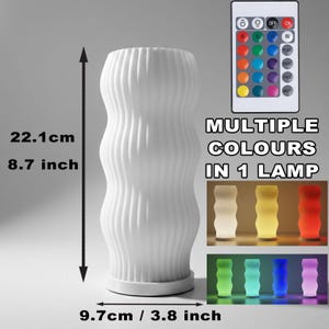 May include: A white, wavy-textured lamp, 22.1 cm tall and 9.7 cm wide, with a remote control. The lamp displays multiple colours, as indicated by the text "MULTIPLE COLOURS IN 1 LAMP".