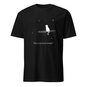 May include: Black t-shirt featuring a white cat silhouette sitting on a rock, gazing at a starry night sky. The text "Why is my bowl empty?" is printed below the cat, creating a whimsical design.