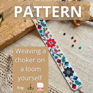 May include: A long, narrow beaded strip featuring a white background with a colorful floral and bird pattern in red, blue, green, and yellow. The strip is finished with metal end caps and is accompanied by a few loose, scattered beads.