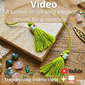 May include: A close-up of two handmade green tassels for a necklace, with white and colorful beads at the top. The image includes text that reads "Video", "A tutorial on creating elegant tassels for a necklace", and "Step-by-step instructions".