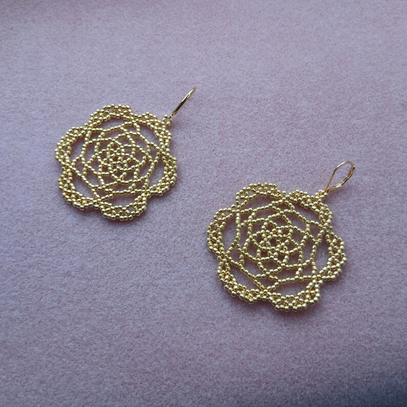 May include: A white ceramic mug with a black handle and the text "But First, Coffee" in a bold, black font. The mug is set against a blurred background, suggesting a cozy setting.