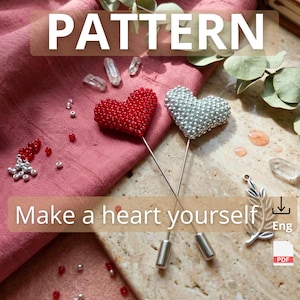 Könnte beinhalten: Zwei herzförmige Anstecknadeln, eine rote und eine silberne, werden auf rosa Stoff gezeigt. Die Anstecknadeln bestehen aus kleinen Perlen. Das Bild enthält auch den Text "PATTERN" und "Make a heart yourself".