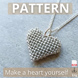 May include: A silver beaded heart pendant on a silver chain. The heart-shaped pendant is made of small, round silver beads. The image includes the text "PATTERN" and "Make a heart yourself".