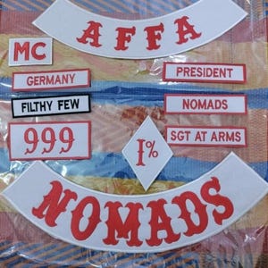 May include: A collection of embroidered patches with various text and symbols. The patches include the words "AFFA", "NOMADS", "GERMANY", "PRESIDENT", "SGT AT ARMS", "FILTHY FEW", "999", "1%", and "MC". The text is in red and black on white backgrounds.