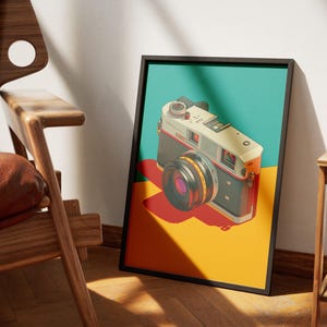 May include: A framed art print featuring a vintage camera illustration. The camera is depicted in a retro style with a black, silver, and orange color scheme, set against a teal, yellow, and red background. The artwork is displayed in a black frame.