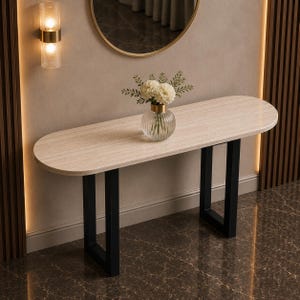May include: A console table with an oval-shaped light wood grain top and two black metal U-shaped legs. A clear, vertically ribbed glass vase containing a bouquet of white flowers sits in the centre of the table surface.