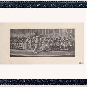 May include: A framed black and white print of a group of people in period clothing. The print is in a black ornate frame with a white mat. A decorative round mirror and a candle holder are also visible.