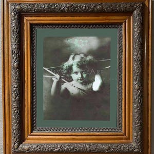 May include: A vintage-style framed print featuring a sepia-toned image of a cherubic figure. The frame is ornate, with a dark brown finish and detailed floral carvings. The print is set against a dark green background.