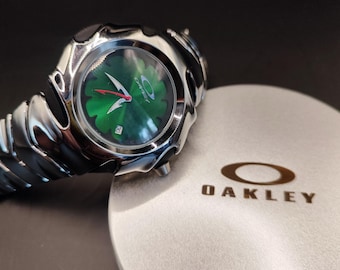 Reloj Oakley Blade Style: un reloj de pulsera futurista plateado con diseño de flores verdes Y2K