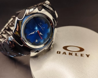 Reloj Oakley Blade Style: un reloj de pulsera futurista plateado con diseño de flores azules Y2K