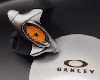 Reloj Oakley estilo torpedo – Reloj de pulsera futurista Y2K con esfera naranja y correa negra.