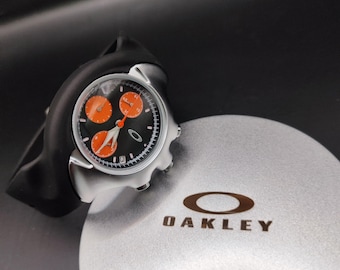 Reloj Oakley estilo Detonator – Cronógrafo naranja con esfera negra, estilo futurista Y2K.