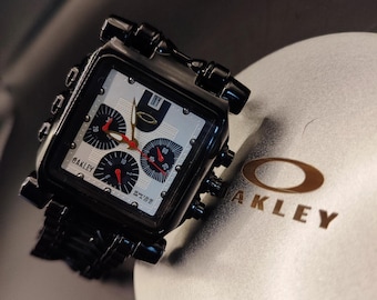 Cronógrafo Oakley Minute Machine Style: reloj cuadrado de acero negro con esfera plateada, estilo años 2000
