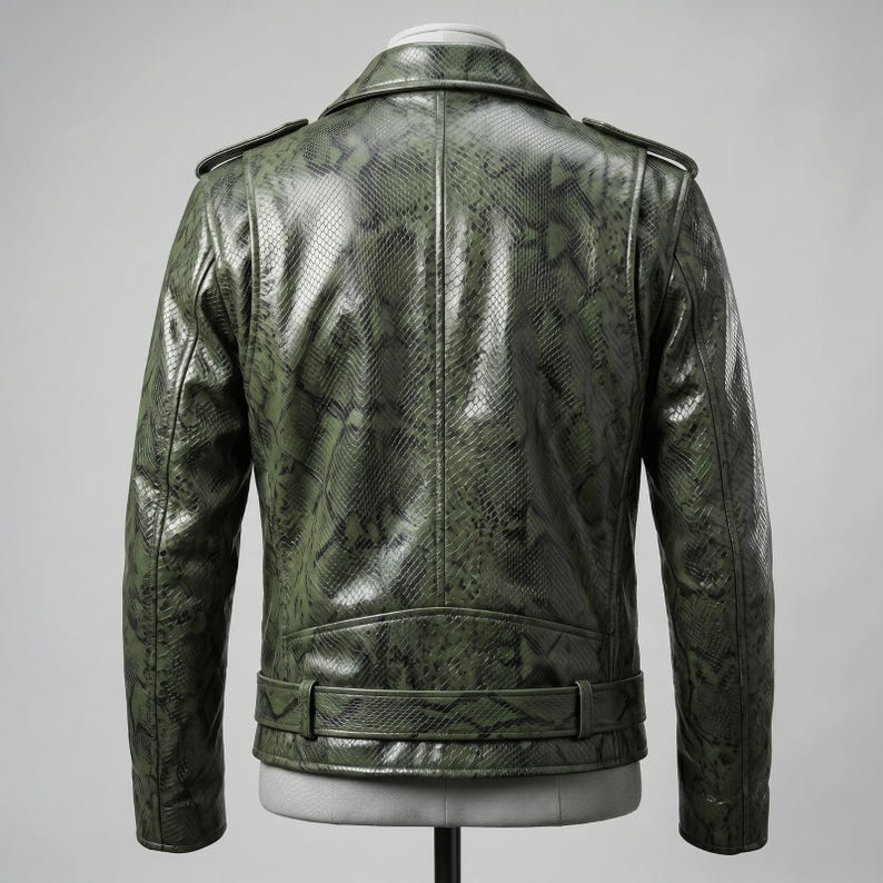 Peut inclure: Veste en cuir vert &agrave; motif peau de serpent, de style motard classique. Elle pr&eacute;sente un col crant&eacute;, des &eacute;paulettes et une ceinture &agrave; la taille. La veste est pr&eacute;sent&eacute;e sur un mannequin, mettant en valeur sa coupe ajust&eacute;e et ses d&eacute;tails.